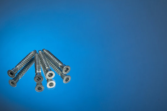 Countersunk wood screws on a blue background.