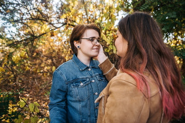 Obraz premium Charming young women kissing gently loving each other stroking touching face skin enjoying romantic tender moments on picnic date in the countryside.