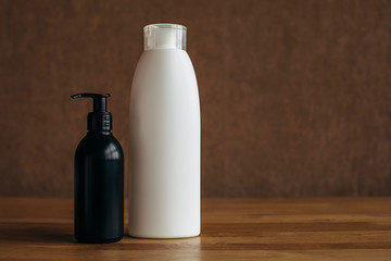 White and black plastic bottle with hand sanitizer on a beige background. Body cosmetics .