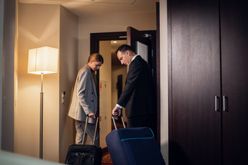A beautiful young business couple leaving their hotel room with