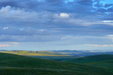Rain clouds over distant hills at sunset. Zabaykalsky Krai. Russia.