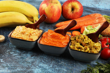 Bowls with baby food. Green, yellow and orange baby puree with fresh organic vegetables and juicy fruits