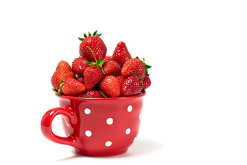 Strawberries in big red cup isolated on white background Close up 