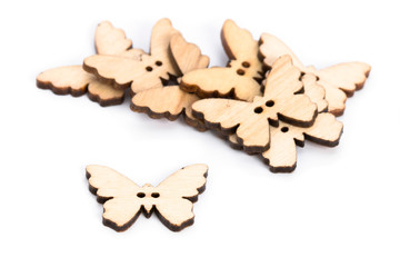 Wooden curly button with two holes on a white background. Butterfly button