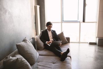 Businessman works from remote at house with a laptop due to coronavirus quarantine.