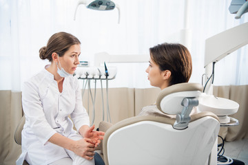 Female dentist discussing a report with her patient at the clini