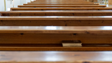 Wooden Benches in Catholic Church. Catholic Temple Seats, Blurred Background. Religious Background. Divine Light, Grace, Hope Concept.