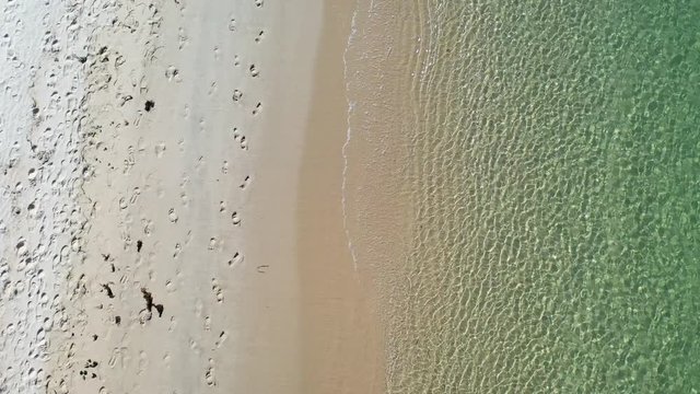 Top down view of the perfect white sandy beach with breaking waves. Transparent sea water. Paradise and desert beach in Troia, Setubal, Portugal