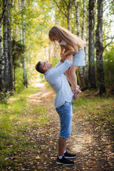 Happy young father playing with child outside in park.