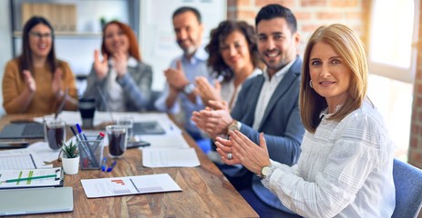Group of business workers smiling happy and confident. Working together with smile on face looking at the camera applauding at the office