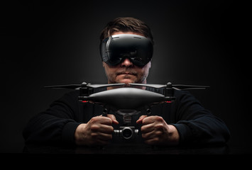 drone pilot in virtual glasses on a dark background - obrazy, fototapety, plakaty