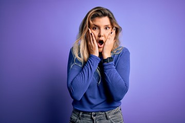 Young beautiful blonde woman wearing casual t-shirt over isolated purple background afraid and shocked, surprise and amazed expression with hands on face
