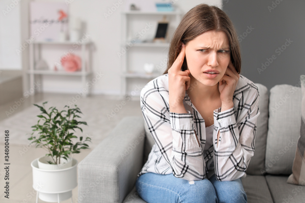 Poster Young woman suffering from loud noise at home