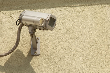 Close-up white security surveillance camera on the wall of a apartment house. Concept  territory protection