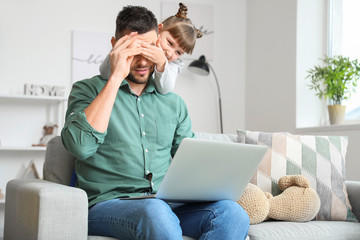 Little daughter keeping father from his work at home