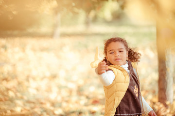 happy little child, baby girl laughing and playing in the autumn on the nature walk outdoors.