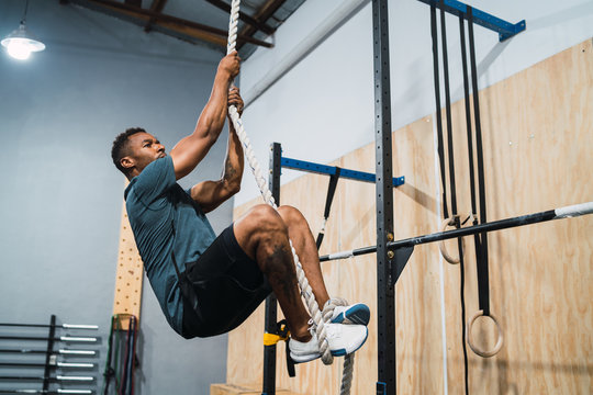Athletic man doing climbing exercise.