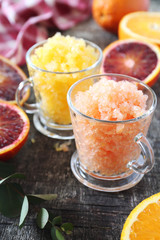 Orange granita, frozen summer dessert in two cups and  fresh orange fruits