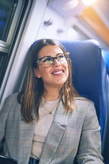Young beautiful woman smiling happy and confident. Sitting with smile on face travelling by train