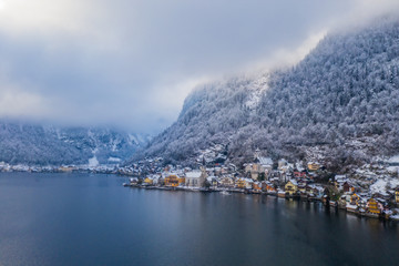 Fototapeta na wymiar Image of cold and snowy winter in Austria. Beautiful mountain and nature at Hallstatt near Obertraun city opposite the Hallstatter See lake at foggy weather. January 2020