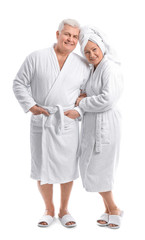 Mature couple in bathrobes on white background