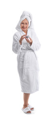 Mature woman in bathrobe and with jar of cream on white background