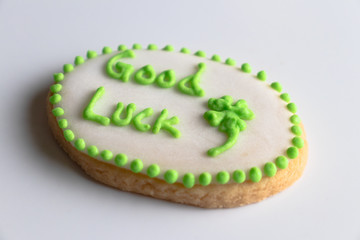 tilted shot of a cookie with good luck written on it with a clove on a white background