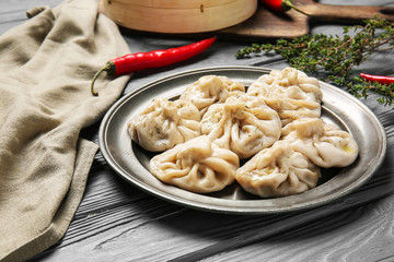 Plate with tasty dumplings on wooden background