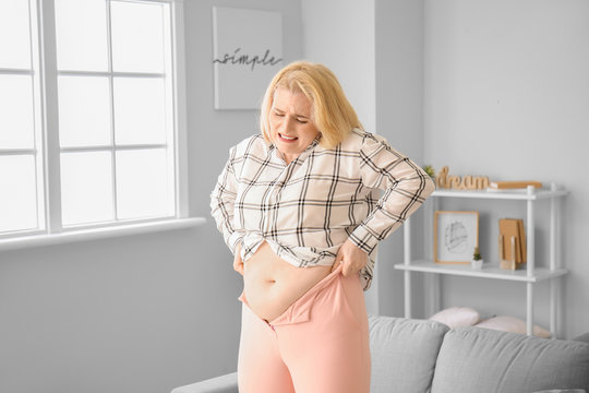 Troubled Overweight Woman In Tight Clothes At Home