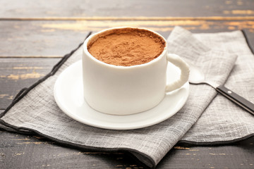Chocolate cake in shape of coffee cup on dark wooden background