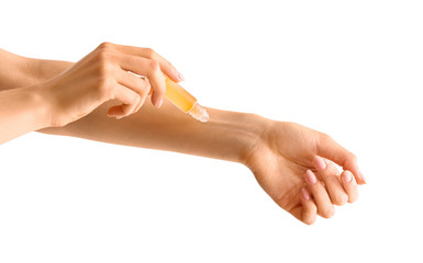 Woman applying roll-on perfume onto her hand against white background