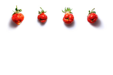 Trendy ugly food fresh red strawberry on white isolated background with shadows and copy space. Misshapen produce, food waste problem concept