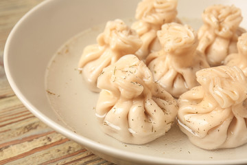 Plate with tasty dumplings on table, closeup