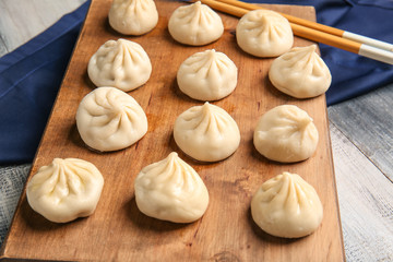 Board with tasty dumplings on table