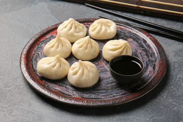 Plate with tasty dumplings on dark background