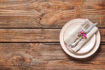 Beautiful table setting with floral decor on wooden background