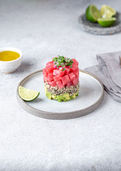 Tuna tartare tartar with avocado and quinoa. gourmet presentation with culinary ring on wite plate