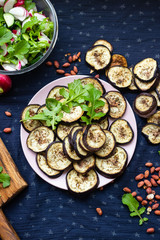 Baked roast or grill eggplants, aubergine slices with rucola herb. Vegan food lunch