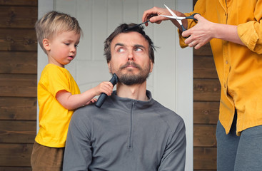 Family haircut at home during quarantine lockdown when closed all hairdressers. Mother cutting hair...
