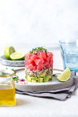 Tuna tartare tartar with avocado and quinoa. gourmet presentation with culinary ring on wite plate