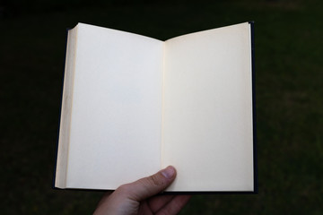 White open notebook held by hand. POV.