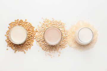 Glasses of different milk on white background