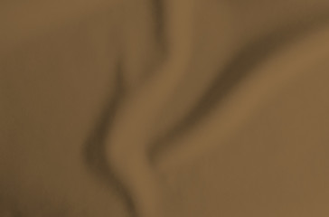 Wavy brown fabric texture. Folded clothes for background
