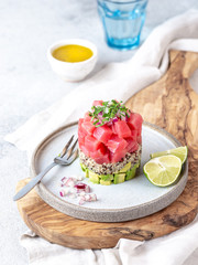 Tuna tartare tartar with avocado and quinoa. gourmet presentation with culinary ring on wite plate