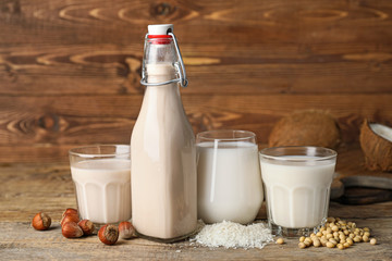 Different milk on wooden background