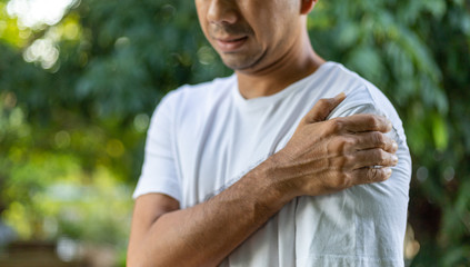 Asian men feel shoulder pain outdoor