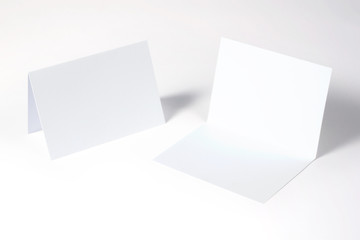 Blank bi-fold invitation, greeting cards isolated on white to showcase your event presentation. 3d illustration.