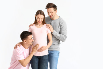 Gay couple with pregnant woman on white background