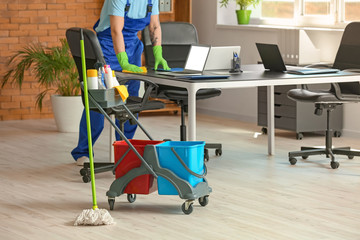 Male janitor cleaning in office