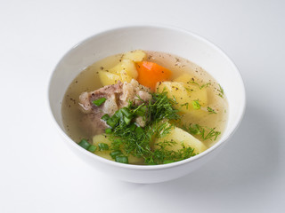 Shurpa soup. Beef with potatoes and carrots in a broth in a white bowl. Side view